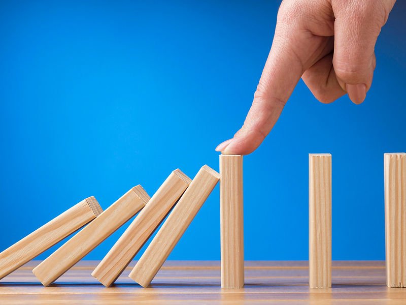 Domino pieces falling, representing risk and project momentum